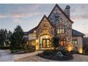 An impressive stone exterior with an arched entryway and stylish double doors at 938 Crescent River Pass, Suwanee, GA 30024