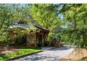 Stone outbuilding featuring wood supports and a stone-paved driveway at 938 Crescent River Pass, Suwanee, GA 30024