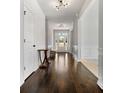 Inviting foyer with hardwood floors, elegant lighting, and wainscoting detail at 141 Aylesbury Blvd, Mcdonough, GA 30252