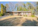 Cozy brick home with a covered driveway and a small wooden porch at 928 Magna Carta Nw Dr, Atlanta, GA 30318