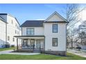 Charming two-story home with a welcoming front porch and modern design elements under a clear sky at 2357 Lynn Iris Dr, Decatur, GA 30032
