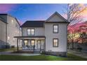 Beautiful two-story home with a covered front porch, modern farmhouse siding, and colorful sunset at 2357 Lynn Iris Dr, Decatur, GA 30032