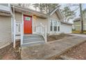 Inviting front entrance with a bright red door, gray stairs, and a walkway to the garage at 2436 Wilshire Ct, Decatur, GA 30035