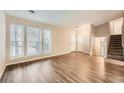 Spacious living room with wood floors, large windows, and a staircase leading to the upper level at 2436 Wilshire Ct, Decatur, GA 30035