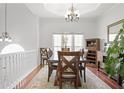 Bright dining room boasts hardwood floors, an elegant chandelier and a large window for natural light at 1772 Ascot Nw Run, Acworth, GA 30102