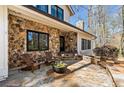 Inviting stone front porch with rocking chairs, stone accents, and a front door at 2415 Roxburgh Dr, Roswell, GA 30076