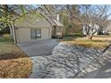 View of the long driveway leading to the attached garage, surrounded by lawn and trees at 649 Woodcrest Manor Dr, Stone Mountain, GA 30083