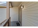 A close-up view of the cozy front porch with dark wood railings and glass door with welcome mat at 649 Woodcrest Manor Dr, Stone Mountain, GA 30083
