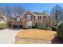 Attractive brick two-story home with well-maintained front yard, two-car garage, and classic architectural design at 407 Spring House Ne Cv, Atlanta, GA 30307