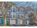 Charming townhomes boast large windows, attached garages, and vibrant turquoise doors, set against a backdrop of mature trees and blue skies at 1059 Park Row North Se, Atlanta, GA 30312