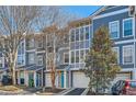 Charming townhomes boast large windows, attached garages, and vibrant turquoise doors, set against a backdrop of mature trees and blue skies at 1059 Park Row North Se, Atlanta, GA 30312