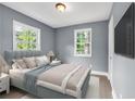 Comfortable bedroom features soft blue walls, hardwood floors, plush bed, and bright natural light at 225 Joe Louis Nw Dr, Atlanta, GA 30314