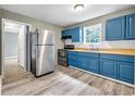 Charming kitchen with stainless steel appliances, stylish blue cabinets, and hardwood floors at 225 Joe Louis Nw Dr, Atlanta, GA 30314