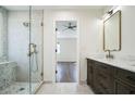 Bathroom featuring double sinks, stone countertops, dark wood cabinets, and a glass shower at 700 Hill Meadow Dr, Dacula, GA 30019