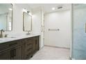 Bright bathroom featuring double sinks, stone countertops, dark wood cabinets, and a glass shower at 700 Hill Meadow Dr, Dacula, GA 30019