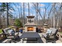 Stone outdoor fireplace and seating area with manicured flower beds for an inviting outdoor experience at 718 Park Haven Ln, Canton, GA 30115