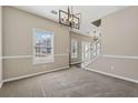 Open dining space features modern chandelier and flows into a living area at 2311 Fall Creek Lndg, Loganville, GA 30052