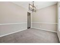 Neutral dining room featuring a modern chandelier and space for entertaining at 2311 Fall Creek Lndg, Loganville, GA 30052