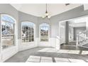 Bright dining room featuring large windows, elegant chandelier, and neutral color palette at 2740 Barimore Pl, Dacula, GA 30019