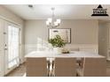 Bright dining room featuring elegant chandelier, white table and wainscotting along the wall at 6939 Hickory Log Rd, Austell, GA 30168