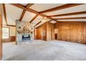 Spacious living room with wood paneling, a stone fireplace, and vaulted ceilings at 5010 Highway 20 Ne, Conyers, GA 30012