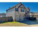 Two-story home with a two-car garage, side yard, and privacy fence at 611 Winners Cir, Locust Grove, GA 30248
