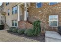 Charming brick townhome entrance with landscaped front yard and iron railing at 656 Sunset Park Dr, Suwanee, GA 30024