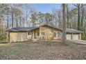 Single-story home with stone facade and attached two car garage set amongst mature trees at 4716 Habersham Sw Rdg, Lilburn, GA 30047
