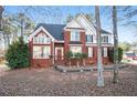 A two-story brick home with a landscaped front yard, black shutters, and a classic architectural design at 2118 Sableshire Se Way, Conyers, GA 30013