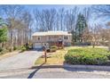 Split-level home with metal roof, front porch, and manicured landscaping in a wooded neighborhood at 3016 Ansley Manor Ct, Snellville, GA 30078
