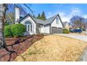 Beautiful home featuring a manicured lawn, complemented by mature trees, stucco facade, and a two-car garage at 1230 Newbridge Ne Trce, Brookhaven, GA 30319