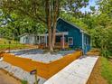 The exterior of the house is surrounded by green trees, a retaining wall, and a long driveway at 1321 Bridges Sw Ave, Atlanta, GA 30310