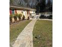 Lush front yard leading to the house with a stone pathway and wooden deck at 4536 Amy Rd, Snellville, GA 30039