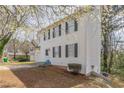 Side view of a white two-story home with black shutters and an attached garage, set on a grassy lot at 2149 Shoals Way, Decatur, GA 30034