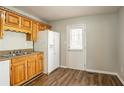 Functional kitchen with white refrigerator, wooden cabinets, and backyard access at 6265 Stoney Cv, Austell, GA 30168