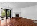 Bright living room featuring a fireplace, sliding glass door, and beautiful wood flooring at 838 Lake Hollow Sw Blvd, Marietta, GA 30064