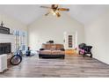 Bright living room featuring vaulted ceilings, a cozy fireplace, and wood-look floors at 114 N Springs Way, Acworth, GA 30101