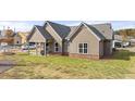 Manicured lawn in backyard with a covered patio and a view of the surrounding community at 213 Saratoga Dr, Acworth, GA 30102