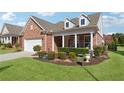 Inviting home with a classic brick facade, dormer windows, and lush front yard at 2975 Thistle Trl, Suwanee, GA 30024