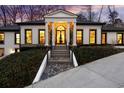 Elegant home featuring a grand entrance with columns, stone accents, and meticulously maintained landscaping at 3565 Haddon Hall Nw Rd, Atlanta, GA 30327