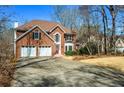 Traditional brick home boasts a well-maintained lawn, two car garage, and mature trees at 724 Laurel Chase Sw, Marietta, GA 30064