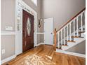 Bright foyer features hardwood floors, staircase with white railings, and a decorative front door at 724 Laurel Chase Sw, Marietta, GA 30064