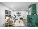 Bright living room with refinished hardwood floors and a decorative green fireplace at 1027 Mount Airy Sw Dr, Atlanta, GA 30311