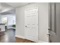 Bright hallway with hardwood floors, a white door, and an entrance into an open concept living space at 1074 Peachtree Ne Walk # B306, Atlanta, GA 30309