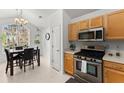 Bright eat-in kitchen with stainless steel appliances, wooden cabinets, and natural light from the large window over the table at 2405 Landrum Ct, Lawrenceville, GA 30043