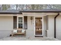 Inviting front porch with a wooden bench, decorative pillows, and a charming front door with sidelight at 2031 Audubon Ne Dr, Atlanta, GA 30329