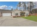 Traditional home boasting a spacious driveway leading to a two-car garage in front of the manicured lawn at 3895 Shelleydale Dr, Powder Springs, GA 30127