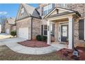 Inviting front entrance with a covered porch, brick columns, and a landscaped garden at 4225 Sharpton Park Dr, Auburn, GA 30011