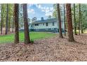 View of the home from the backyard, showcasing a well-maintained lawn, trees, and the property's exterior at 3345 Flowers Dr, Atlanta, GA 30337