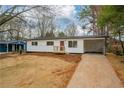 Well-maintained white home with black roof, red door, and tidy lawn at 1506 Sycamore Nw Dr, Kennesaw, GA 30152